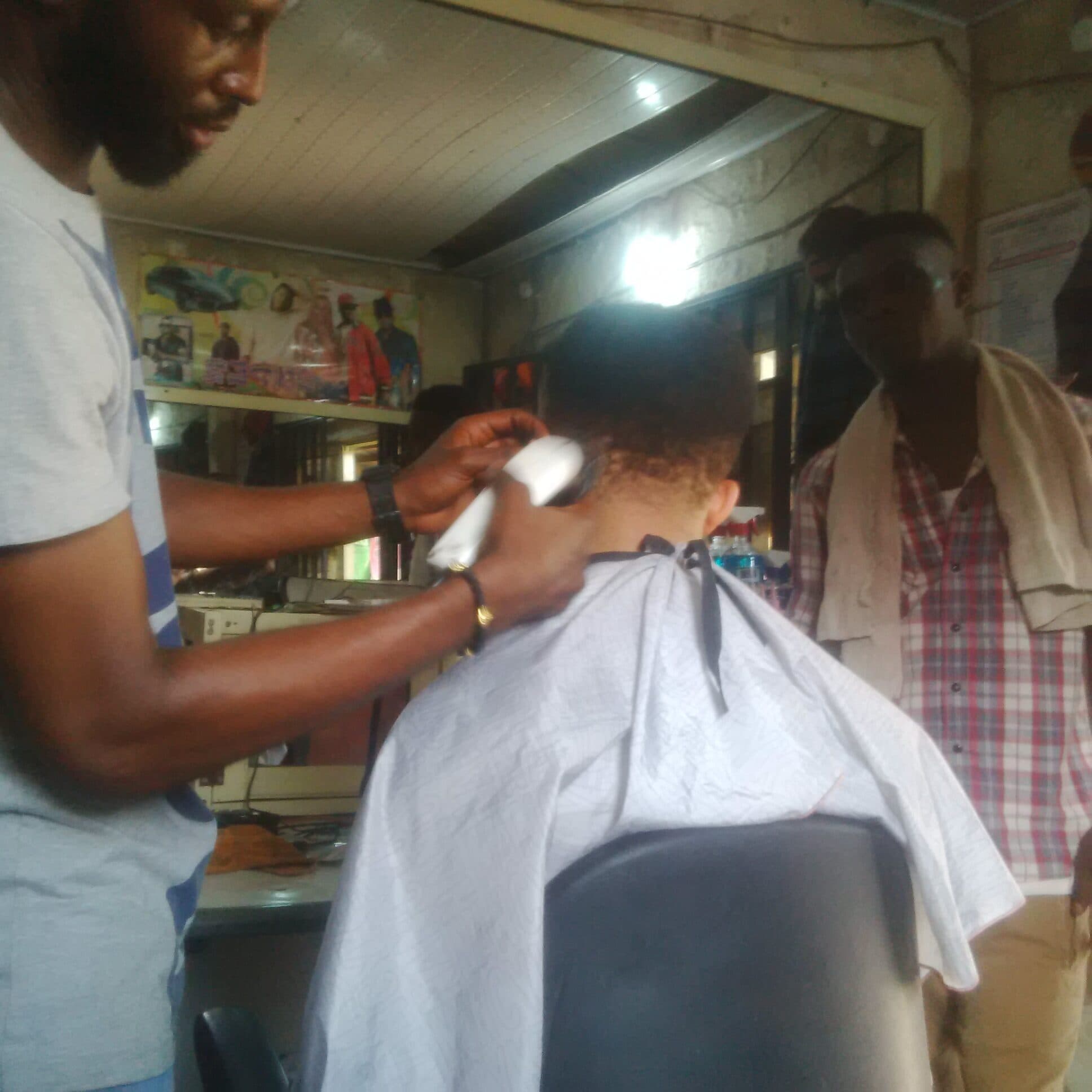 A small barbershop interior lit by a single bulb