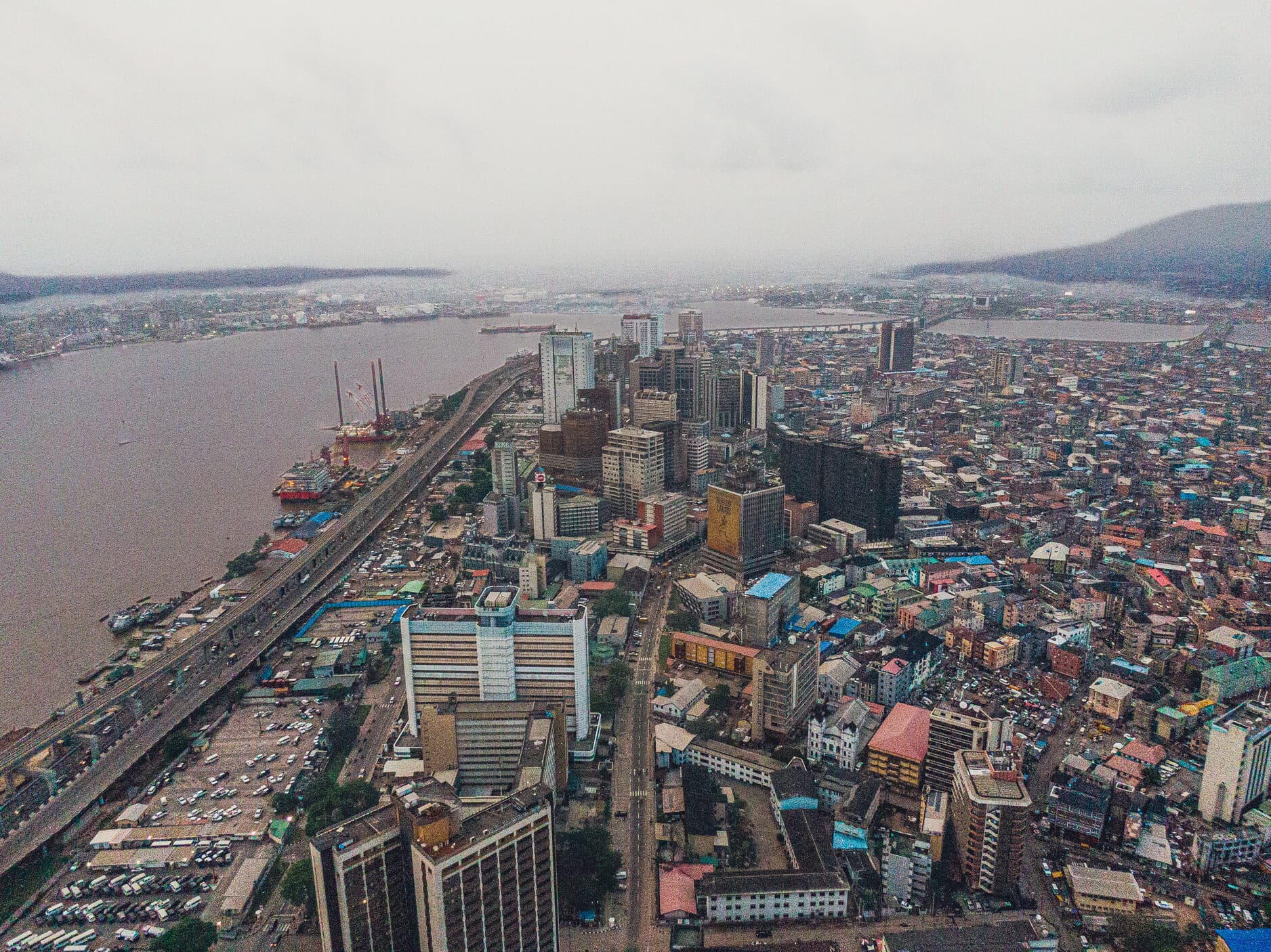 A dense city quarter from the air, high-rises beyond