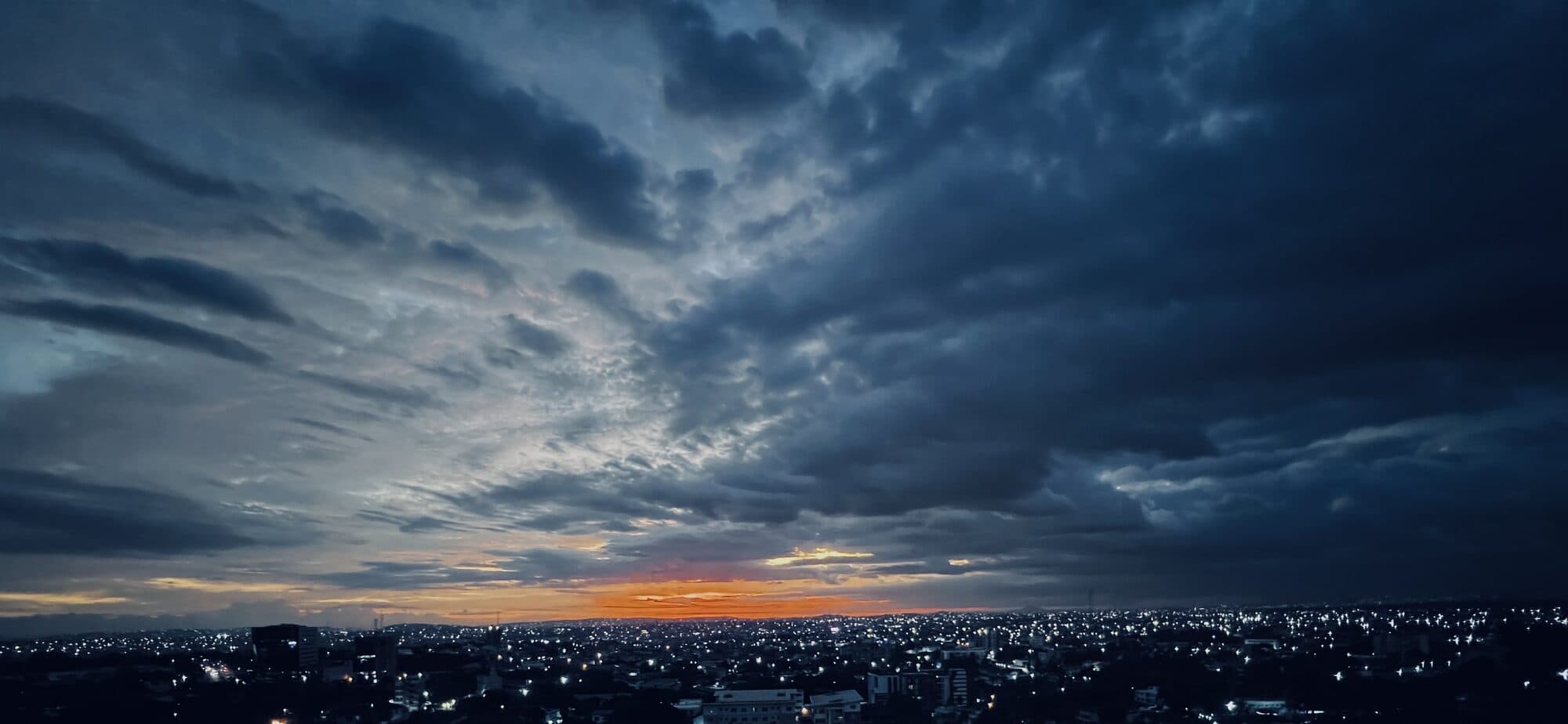 Storm cloud building over a city at dusk