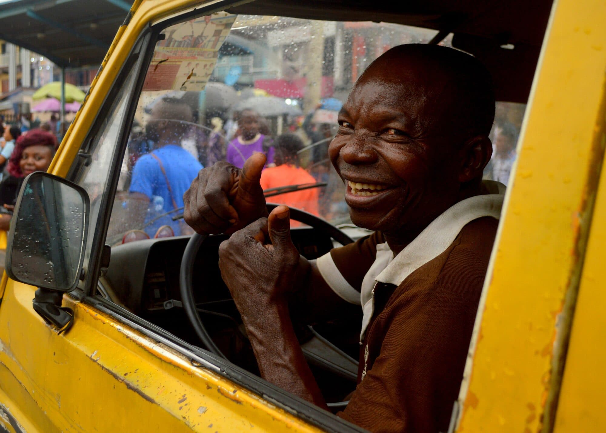 The driver of a yellow bus at the wheel