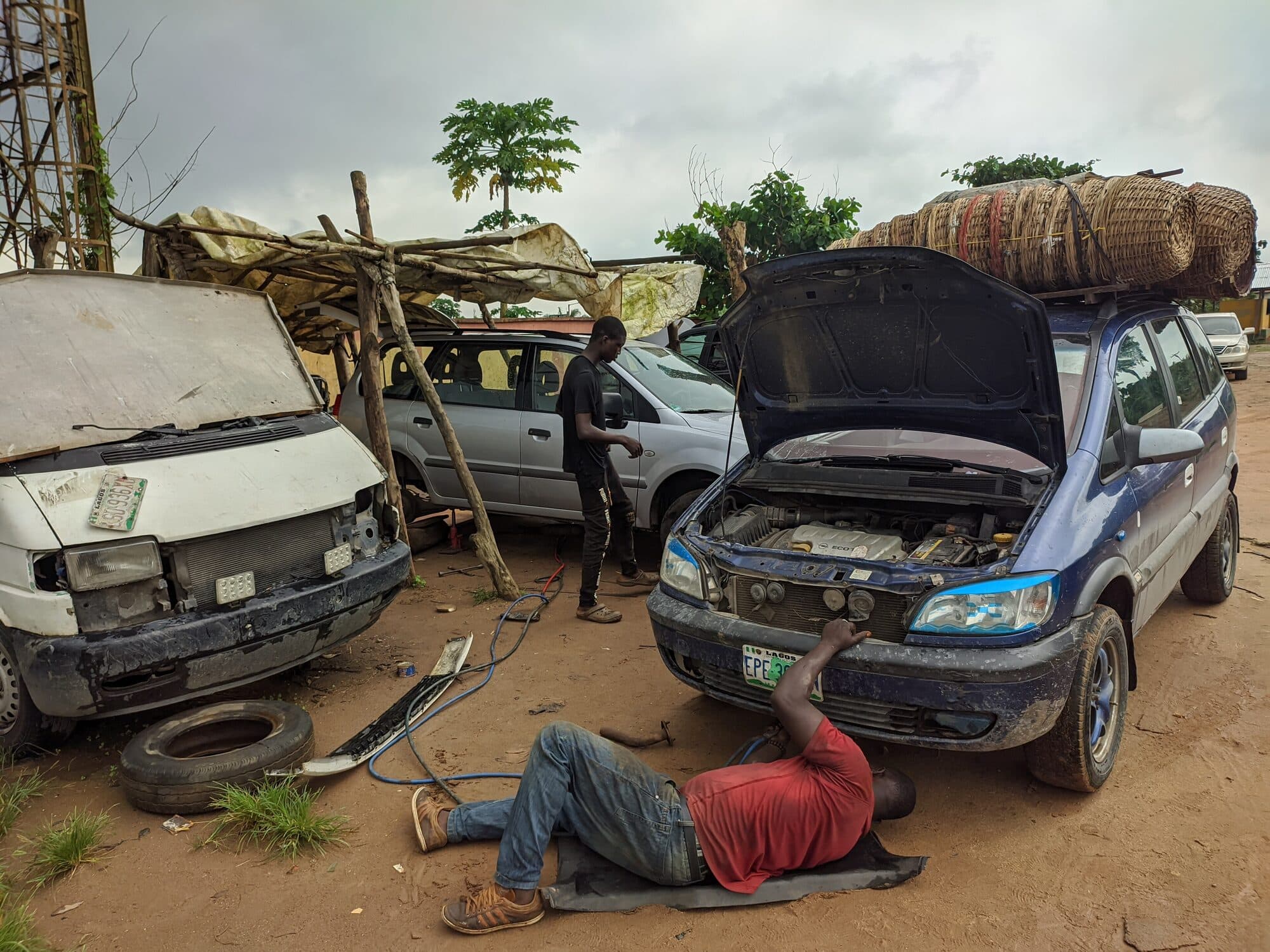 Cars under repair in the open at a roadside mechanic yard