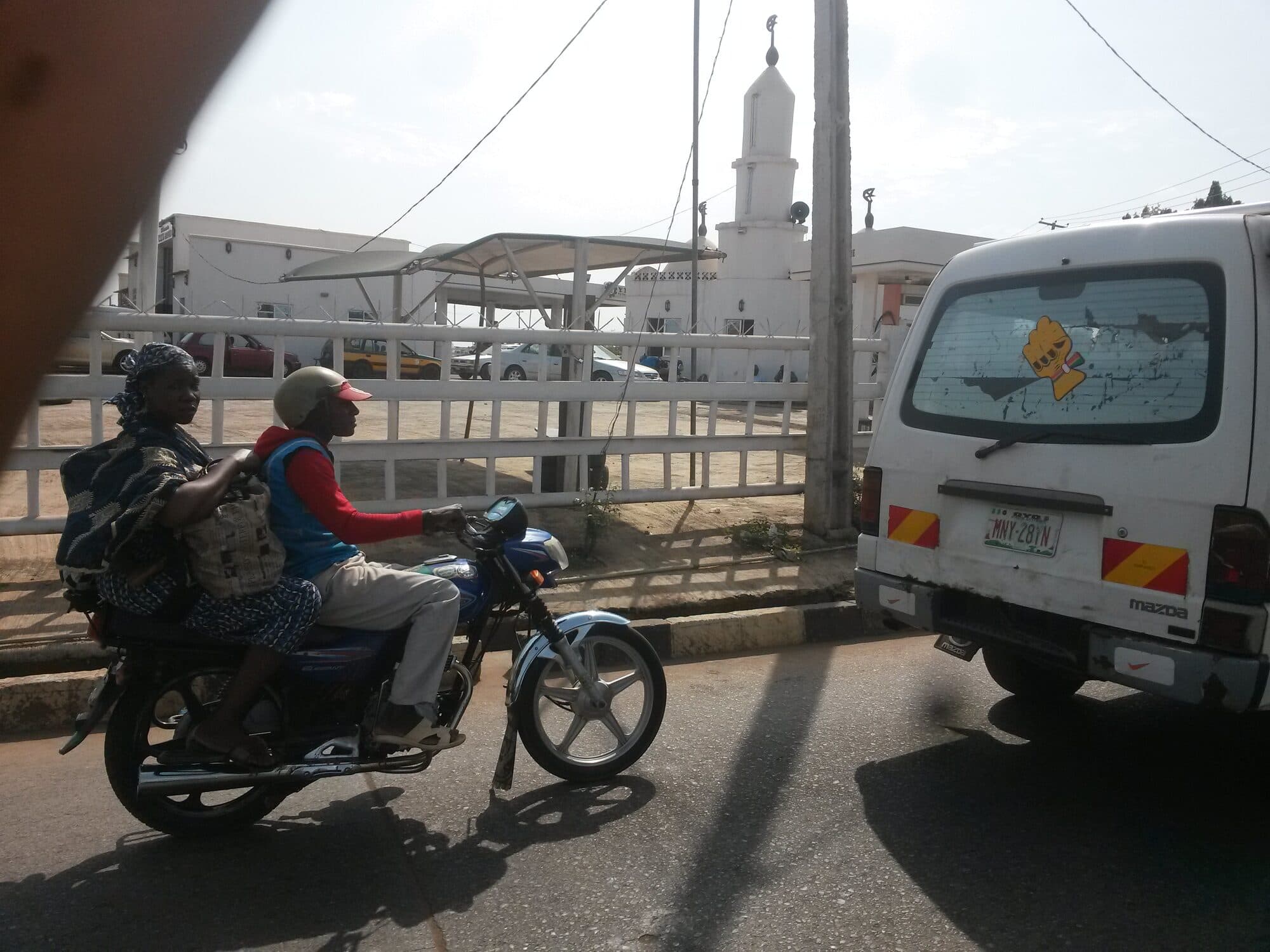 A motorcycle rider from behind, following traffic