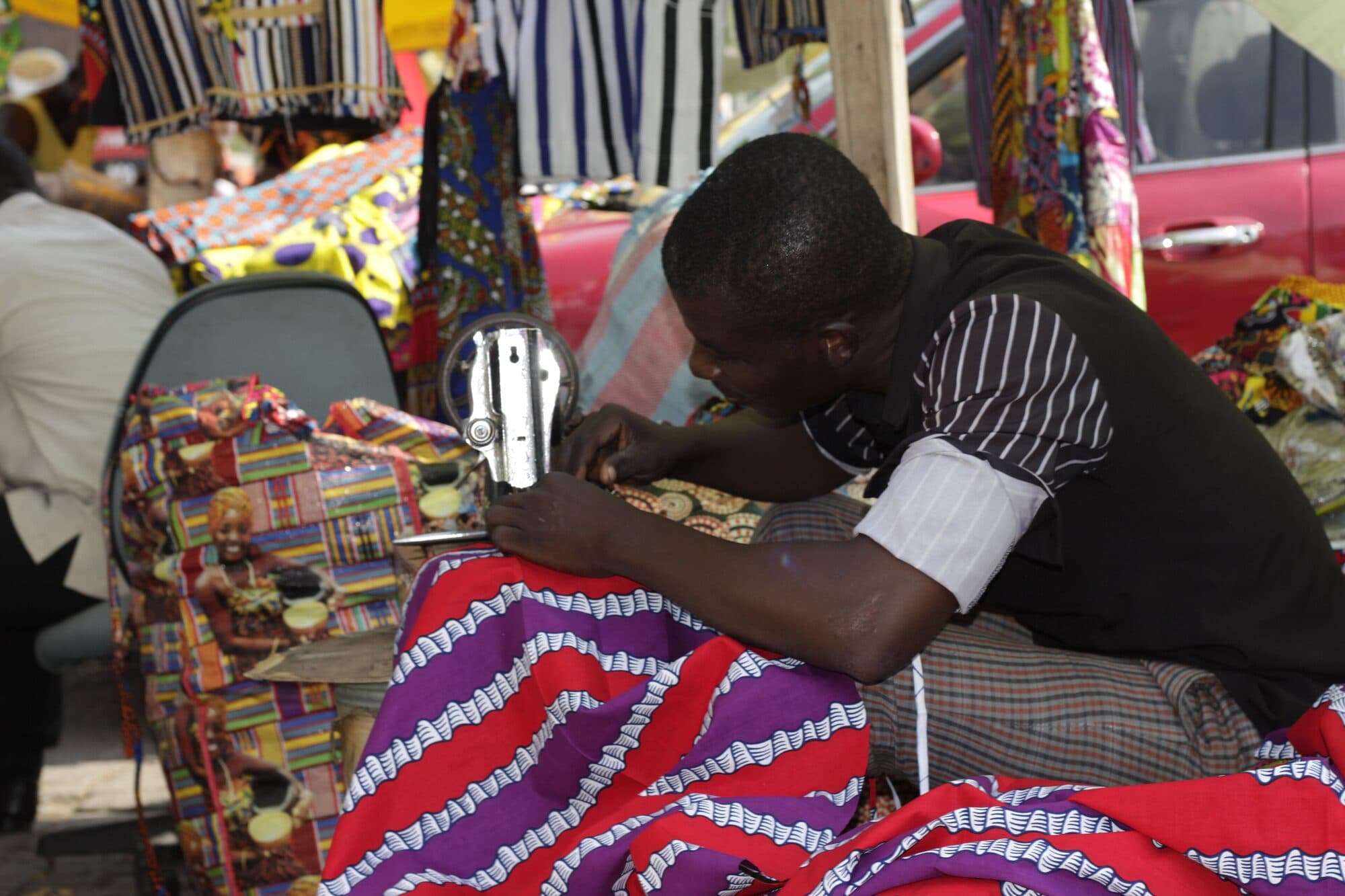 A tailor working over a bolt of printed cloth