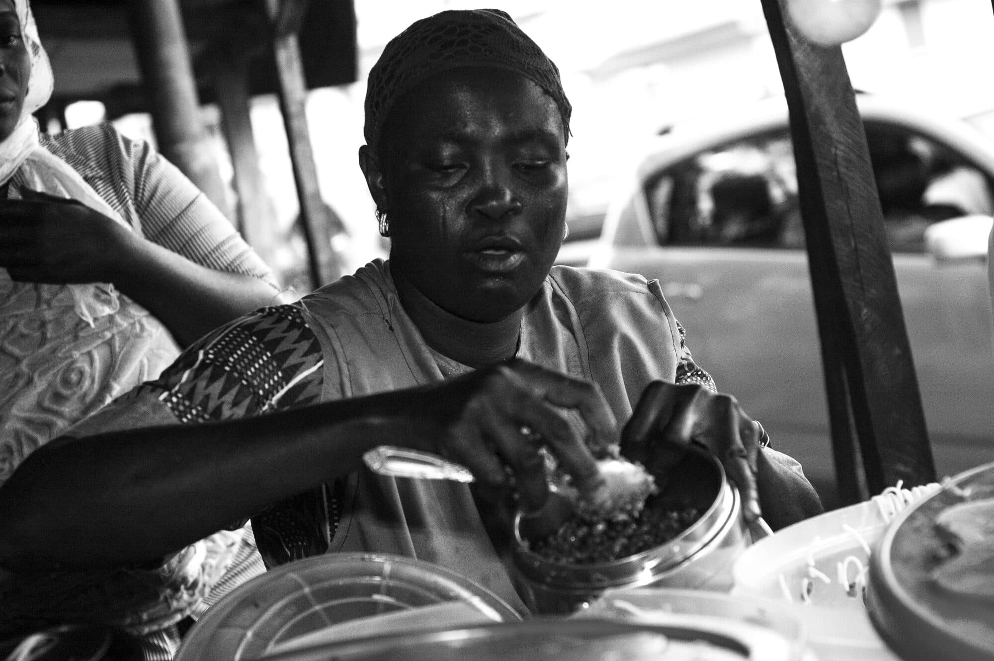 A street food seller at her stand, black and white