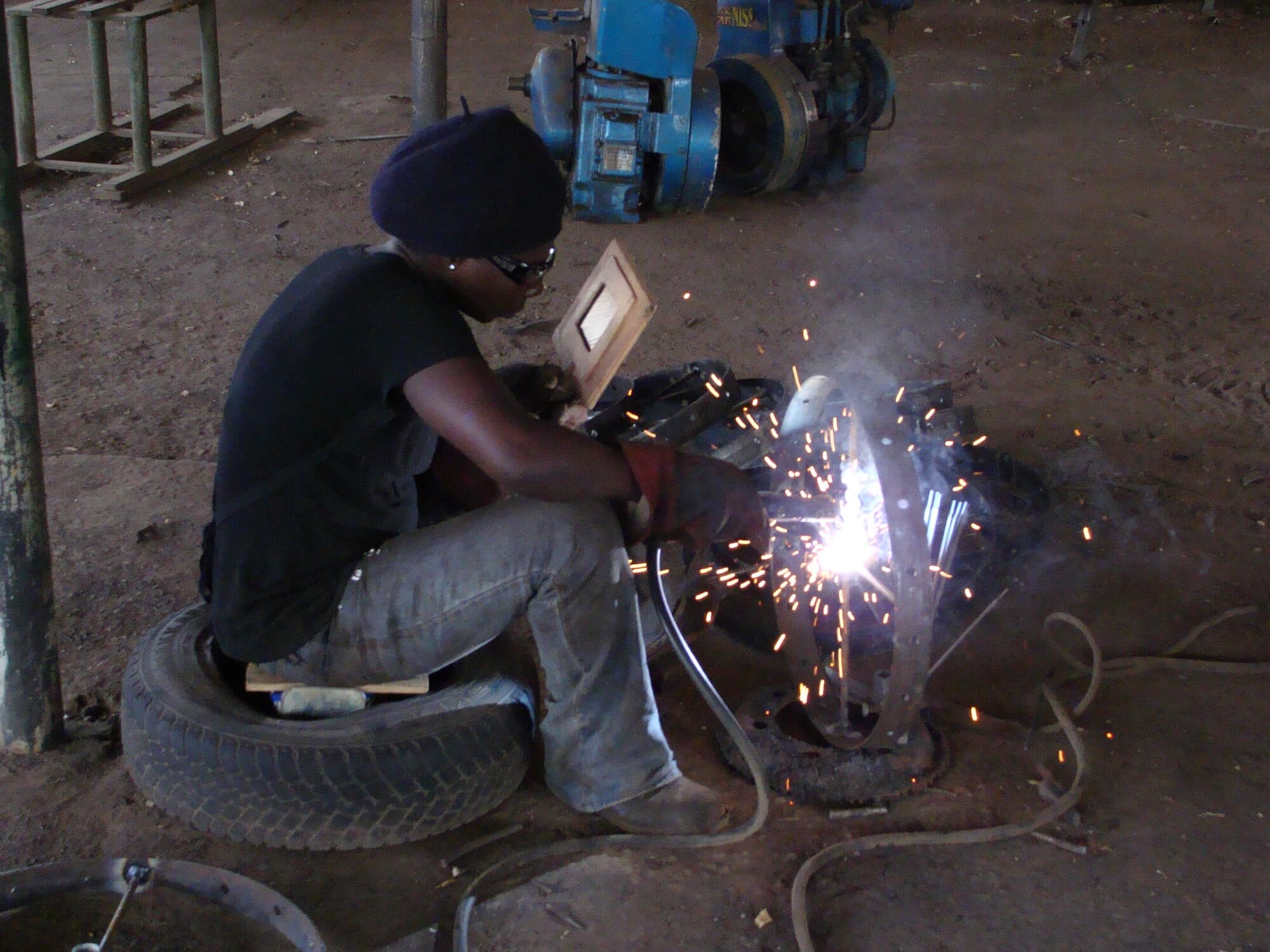 A welder at work on a kerb, a burst of sparks off the weld